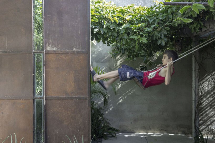 a lush garden grows the entire height of albor arquitectos’tower house in cuba