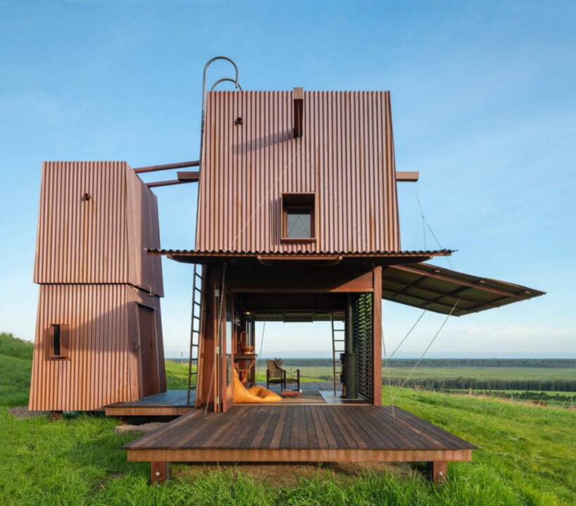casey brown sets copper-clad cabin with movable awnings within lush australian paddocks