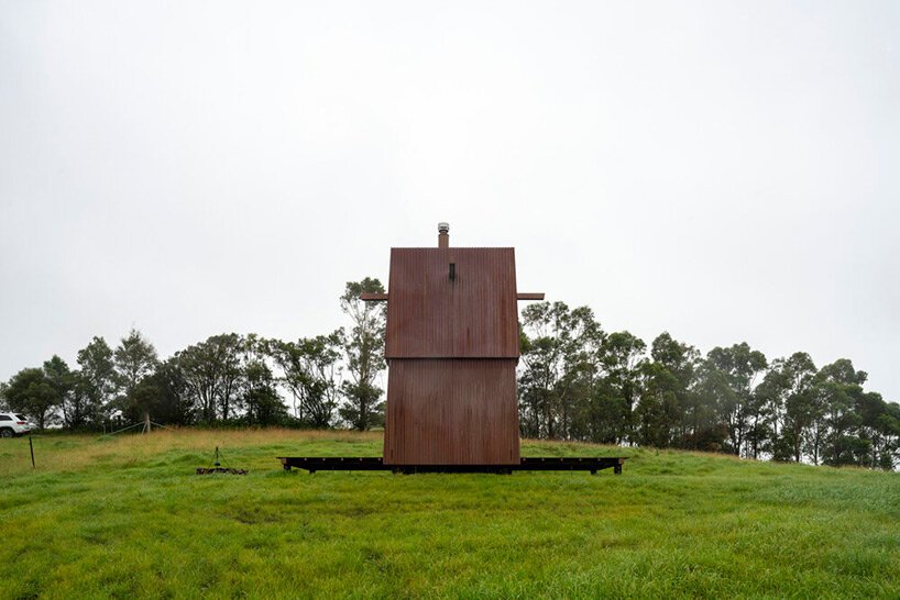 casey brown sets copper-clad cabin with movable awnings within lush australian paddocks
