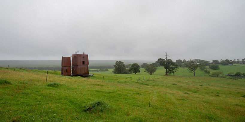 casey brown sets copper-clad cabin with movable awnings within lush australian paddocks