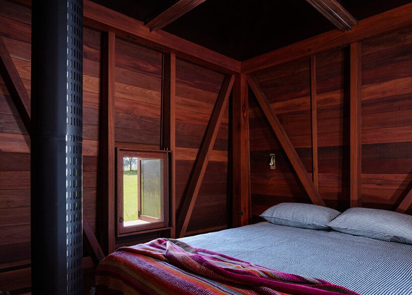casey brown sets copper-clad cabin with movable awnings within lush australian paddocks