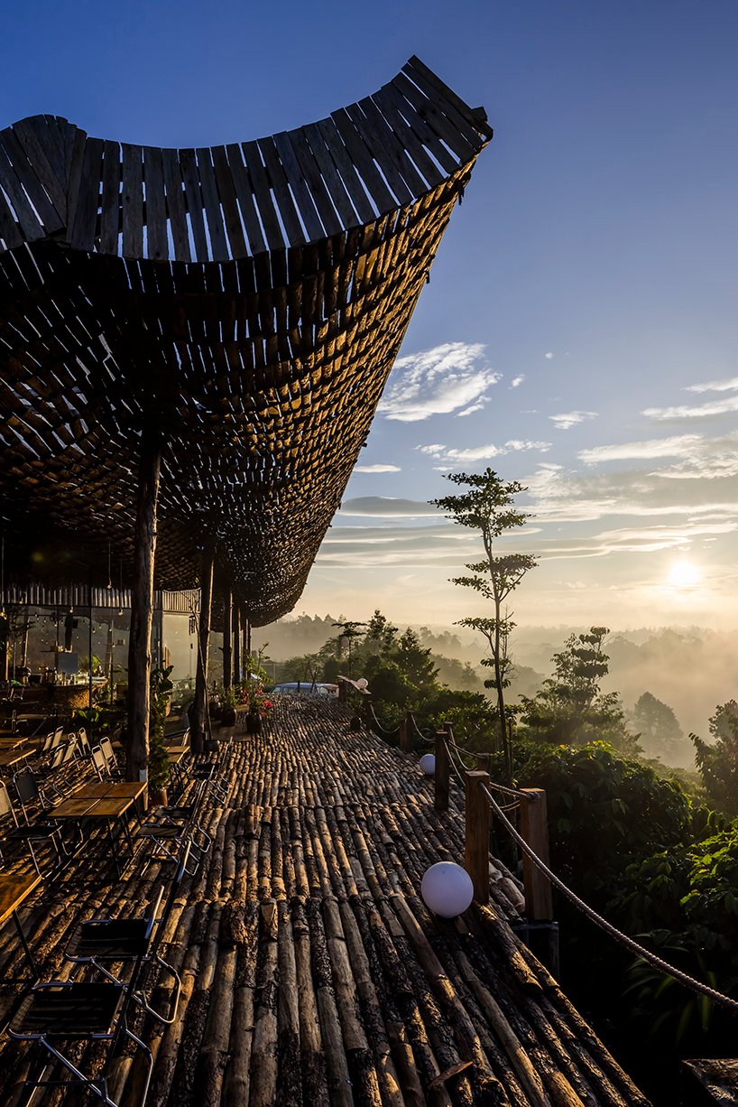 越南乡村景观中的室外咖啡馆上覆盖着穿孔木屋顶