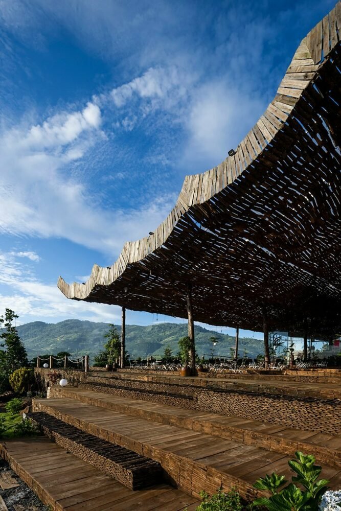 越南乡村景观中的室外咖啡馆上覆盖着穿孔木屋顶