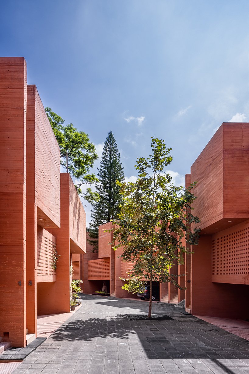 orange-tinted concrete blocks subtly stack residential complex in mexico