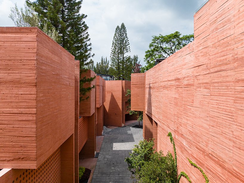 orange-tinted concrete blocks subtly stack residential complex in mexico