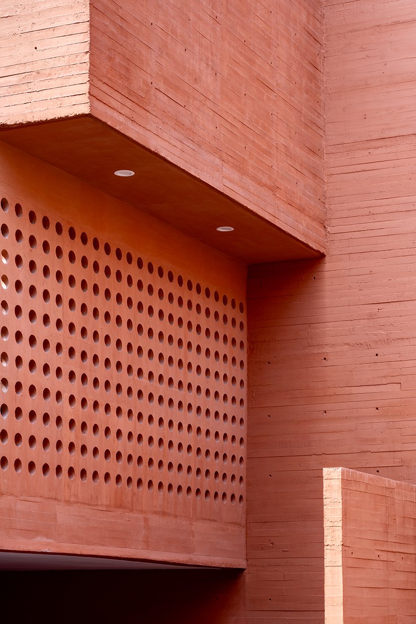 orange-tinted concrete blocks subtly stack residential complex in mexico