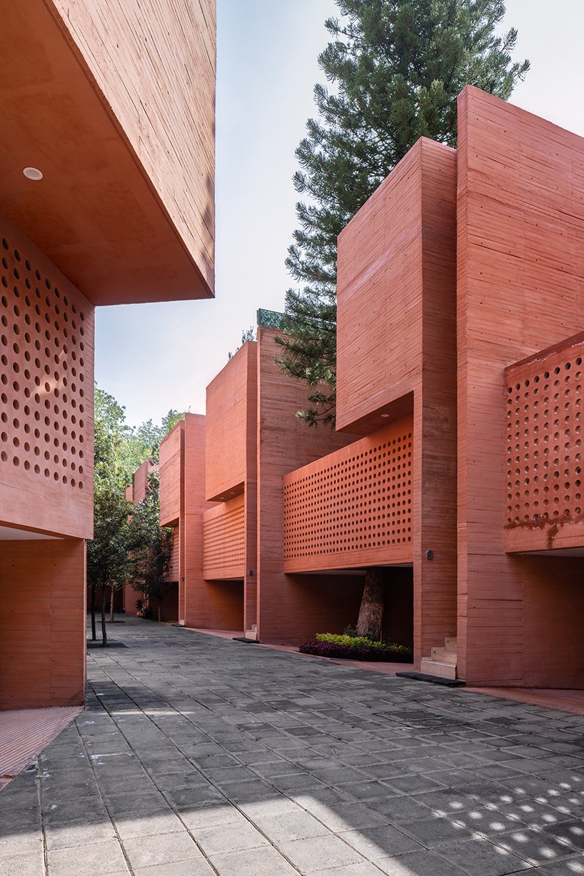 orange-tinted concrete blocks subtly stack residential complex in mexico