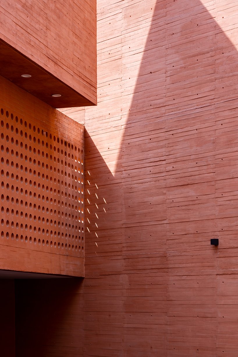 orange-tinted concrete blocks subtly stack residential complex in mexico