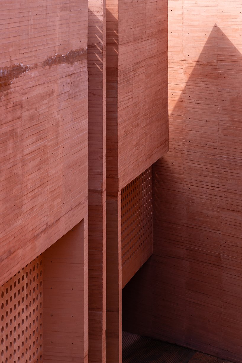 orange-tinted concrete blocks subtly stack residential complex in mexico