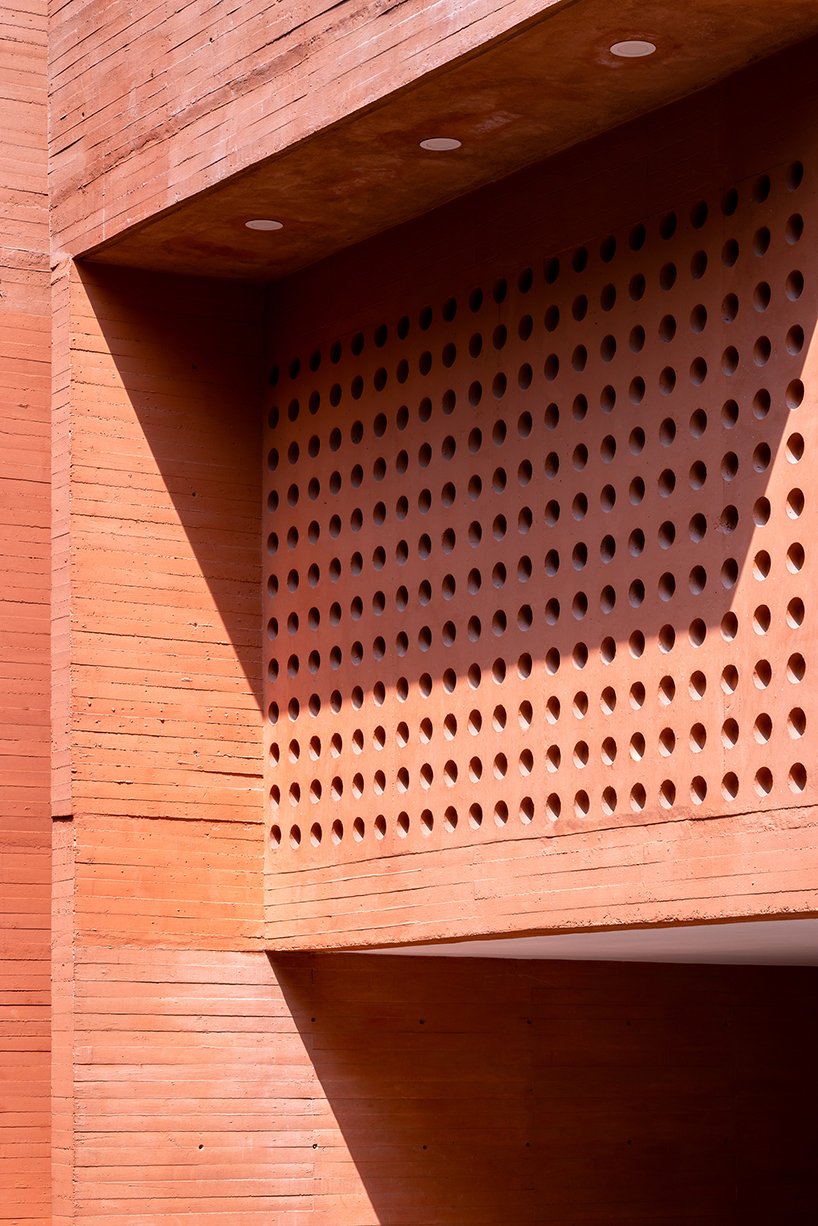 orange-tinted concrete blocks subtly stack residential complex in mexico