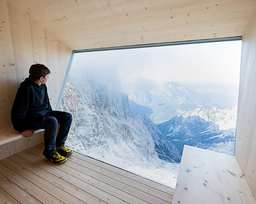 this rough-hewn inclined cabin is suspended on a cliff in the italian dolomites