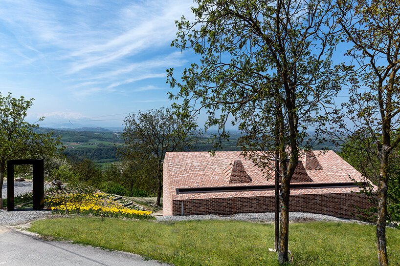 studioata 沿着意大利朗格山嵌入了一座多面砖住宅