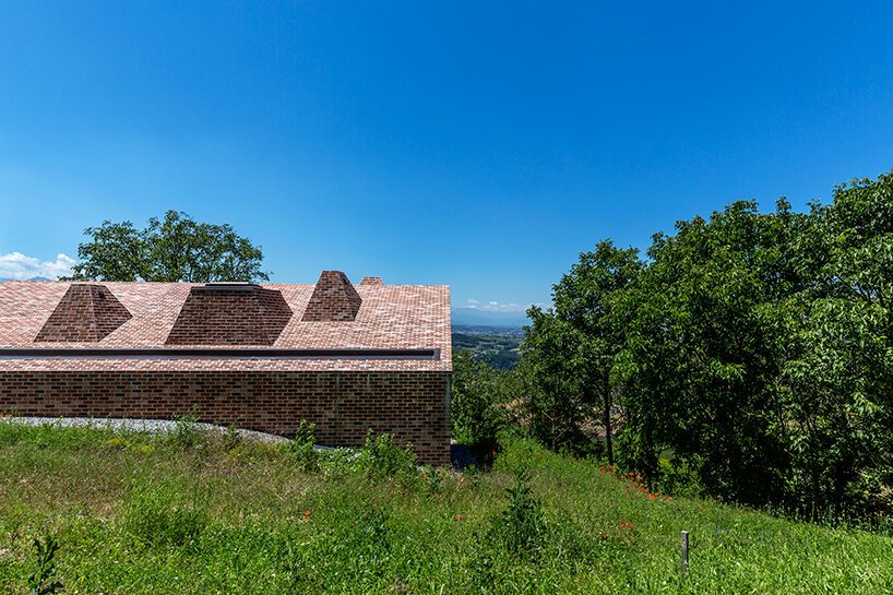 studioata 沿着意大利朗格山嵌入了一座多面砖住宅