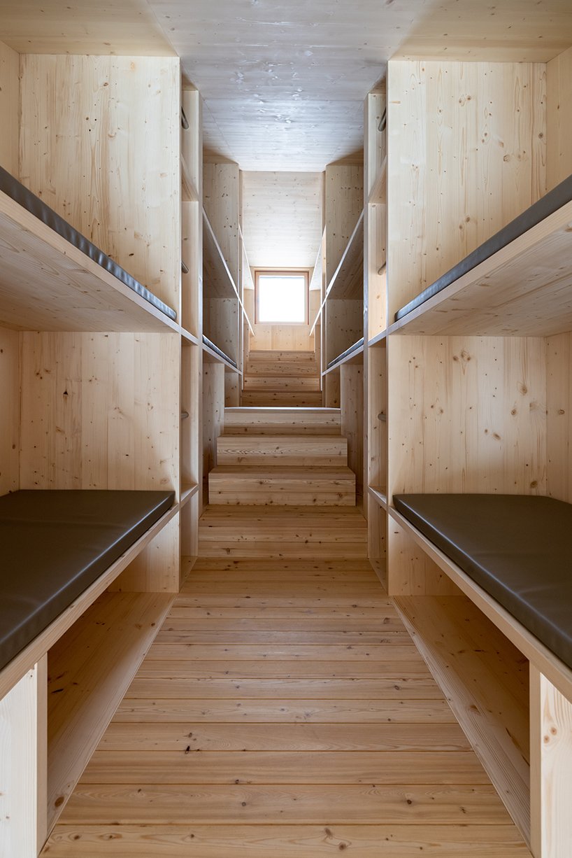 this rough-hewn inclined cabin is suspended on a cliff in the italian dolomites