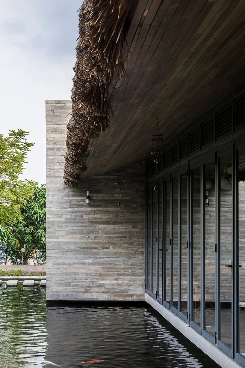 越南宁静的池塘旁有茅草屋顶的房子